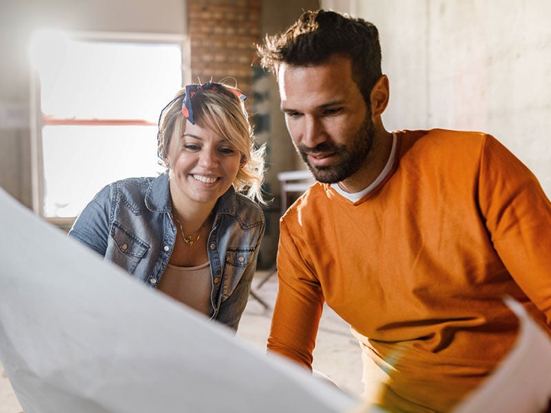 man and woman looking at blueprints